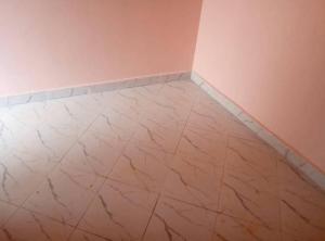 a room with a marble floor and pink walls at Jayson Housing in Wakiso