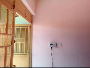 a room with a electrical outlet on the wall at Jayson Housing in Wakiso