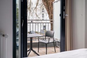 a bedroom with a table and a chair on a balcony at Homaris Nolli Studios in Berlin