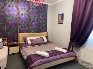 a bedroom with a bed with purple curtains at Hotel Domashnii in Zhytomyr