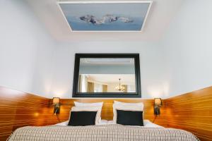 a bedroom with a bed with a mirror on the wall at Boutique Hotel Yöpuu in Jyväskylä +64 photos