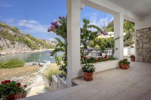 a balcony with flowers and a view of the water at Robinson Agava in Selca kod Bogomolja