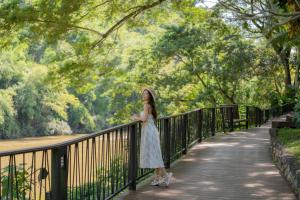 a woman in a white dress standing on a bridge at River Kwai Resotel in Sai Yok +32 photos