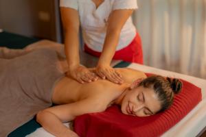 a woman giving a man a massage on a bed at River Kwai Resotel in Sai Yok