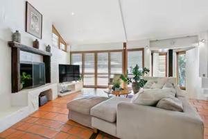 a living room with a white couch and a tv at Little Cove 4BR Home, Pool, Pool table, Sleeps 16 in Noosa Heads +43 photos