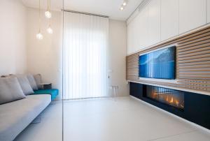 ein Wohnzimmer mit einem TV, einem Sofa und einem Kamin in der Unterkunft B&B Portorosso in Monopoli