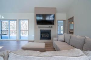 a living room with a couch and a fireplace at Spa Pool Table & Comfort - Chalet le Barista in Brownsburg