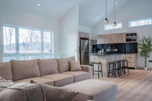 a living room with a couch and a kitchen at Spa Pool Table & Comfort - Chalet le Barista in Brownsburg +57 photos