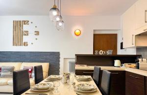 a dining room table with chairs and a kitchen at Nido Alpino - casetta con giardino, vista montagne in Tirano +7 photos