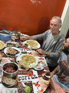 a group of people sitting at a table with food at Periyar Green Bed & Breakfast in Thekkady +16 photos