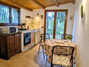 a kitchen with a table with chairs and a microwave at La casa delle Lune in Mombaroccio