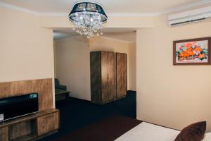 Habitación de hotel con cama y lámpara de araña. en Hotel Bek Samarkand, en Samarkand