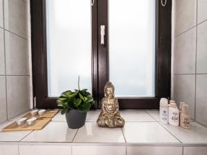 a statue of a buddha sitting on a window sill at Erstklassige 3-Zimmer Wohnung in Leipzig +38 photos