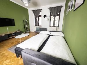 a large bed in a room with a green wall at Erstklassige 3-Zimmer Wohnung in Leipzig