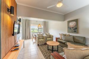 a living room with a couch and a table at Fairway Holiday Accommodation in Hermanus