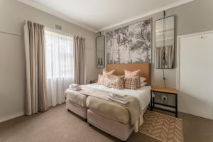 a bedroom with a large bed and a window at Fairway Holiday Accommodation in Hermanus