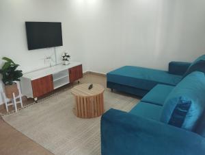 a living room with a blue couch and a tv at Luxe homes in Munyu