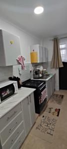 a kitchen with white cabinets and a stove top oven at Luxe homes in Munyu