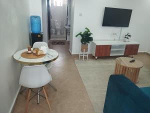 a living room with a table and a tv at Luxe homes in Munyu