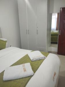 a bedroom with a bed with two towels on it at Luxe homes in Munyu