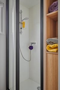 a shower in a bathroom with a glass door at Slow Village Les Ponts de Cé in Les Ponts-de-Cé +69 photos