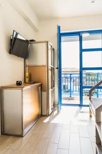 a kitchen with a refrigerator and an open door at ELPIDA Suites - Mandra, Greece in Mándra