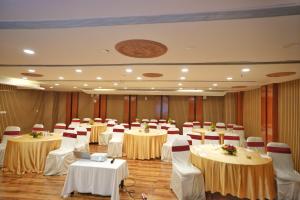 a banquet hall with tables and chairs in it at The Altruist Hitech Hotel in Hyderabad