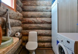 a bathroom with a toilet and a washer and dryer at Käenpesän Aihki in Syöte