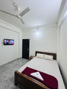 a bedroom with a bed and a tv on the wall at Dubai Inn in Kanjirapalli