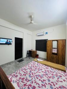 a bedroom with a bed and a tv on the wall at Dubai Inn in Kanjirapalli