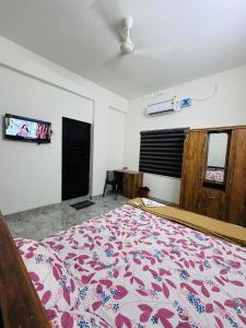 a bedroom with a large bed with a floral bedspread at Dubai Inn in Kanjirapalli