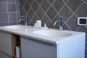two sinks in a bathroom with two faucets at B&B dolcenotte in Gattico