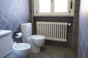 a bathroom with a toilet and a window and a radiator at B&B dolcenotte in Gattico