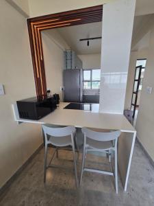 a kitchen with a white table and two chairs at 407 Afsaal in Amanzimtoti
