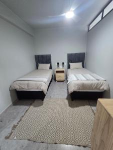 a room with two beds and a table in it at 407 Afsaal in Amanzimtoti +15 photos