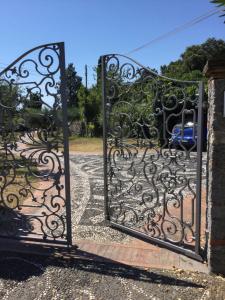 a gate to a driveway with a blue car behind it at B&B Le Palme in Ameglia