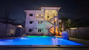 a swimming pool in front of a house at night at Junie Pension House in Moalboal