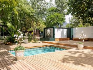 a backyard with a swimming pool and a wooden deck at The Tin Roof in Riebeek-Kasteel