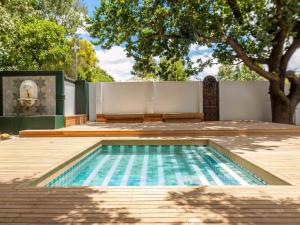 a swimming pool in a backyard with a tree at The Tin Roof in Riebeek-Kasteel