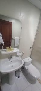 a white bathroom with a toilet and a sink at Maysan Al Mahbas Hotel in Al Khansāk