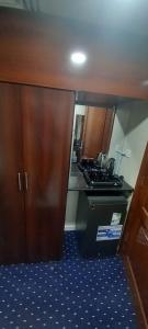 a small kitchen with a stove and a refrigerator at Maysan Al Mahbas Hotel in Al Khansāk