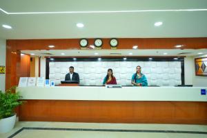 three people standing at a counter in a lobby at The Altruist Hitech Hotel in Hyderabad