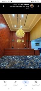 a chandelier in a room with a large bed at Maysan Al Mahbas Hotel in Al Khansāk