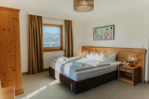 a bedroom with a large bed and a window at Hotel Babymio in Kirchdorf in Tirol +72 photos