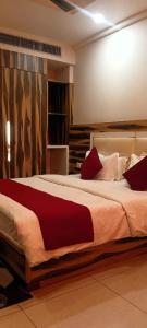 a bedroom with a large bed with red pillows at Hotel President in Bharwain