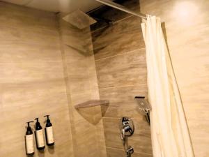 a shower with two bottles of wine in a bathroom at Hotel President in Bharwain +37 photos