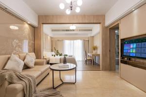 a living room with a couch and a table at RoomMe HOTEL寓洣公寓佛山铂顿祖庙岭南天地店 in Foshan
