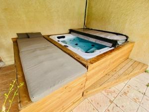 a wooden bed with a hot tub in a room at La Maison Patricia in Aramon +27 photos