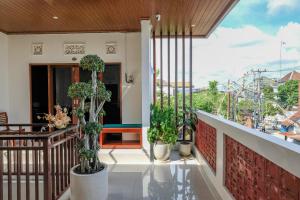 a balcony with potted plants on a house at Urbanview Hotel Arta Guna Casa in Kerobokan