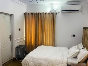 a bedroom with a bed and an orange curtain at Perfect Home in Lagos
